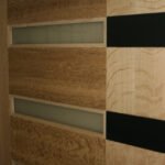 Light wood flush door with six frosted glass slot inserts and black accents — project 027 by Whitebird Woodcraft