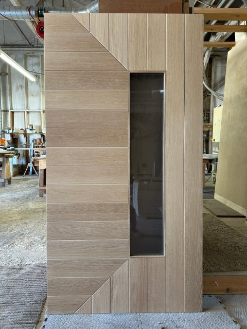 Modern flush door with diagonal triangular accents and vertical glass window insert — project 030 by Whitebird Woodcraft